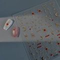 Vista macro de pegatinas 3D para uñas con estrellas y lunas doradas en relieve metálico - CO-392 Estampado en Caliente Oro