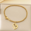 Détail d'un pendentif cœur doré avec cinq cristaux blancs sur une chaîne en acier inoxydable poli - Style Strass Coeur Creux (KB203656-Z)