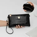 Elegante pochette nera con motivo a coccodrillo, emblema in cristallo e dettagli dorati - Nero