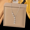 Collana con pendenti a stella argentati e zirconi su un portagioie color champagne - Stile Sei Stelle (8034) / Colore acciaio