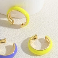 Detail view of colorful enamel C-shape cuff earrings in neon yellow and purple tones - Yellow