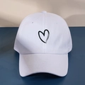Detailed view of the black heart print on a minimalist white washed baseball cap - One Size (57-59cm) / White