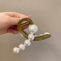 Dettaglio della pinza per capelli verde oliva con grandi perle bianche e finitura lucida - Verde Militare
