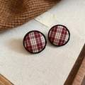 Close-up of red plaid fabric round stud earrings with elegant black metal frames - Silver Needle Round Studs / Red Plaid