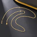 Macro shot of gold flat chain with diagonal cut texture and lobster clasp on black background - Beveled Curb Chain (13) / Gold