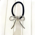 Close-up of a black elastic hair tie with a minimalist silver metal bow charm - Style E / Silver