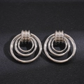 Macro detail of silver geometric hollow circular earrings on a textured black surface - Silver (Silver Pin) / Silver