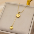 Collier cœur en acier titane doré avec double pendentif sur un coffret à bijoux - Collier à Double Pendentif Coeur