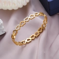 Pulsera de eslabones de corazón dorado con cristales sobre fondo de seda violeta elegante - Dorado
