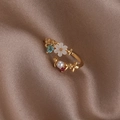 Detail of gold shell flower ring with pearl and heart gemstone on silk background - Pearl Flower (Champagne Gold) (21697)