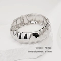 Detailed view of silver hammered cuff bracelet with textured finish on a white stone base - Hammered Silver Minimalist Bangle (SL236) / Silver