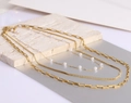 Detail of triple-layer 18K gold-plated chain necklace with elegant white pearls on stone - Gold
