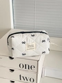 Trousse à cosmétiques matelassée blanche avec motifs de nœuds noirs et fermeture - Petite pochette de rangement octogonale