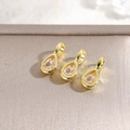 Macro detail of three 18k gold plated teardrop charms with inlaid cubic zirconia stones - Champagne