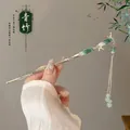 Detailed macro view of New Chinese style hair pin with green bamboo nodes and metal tassels - Bamboo Stem 9k Gold
