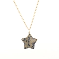Dettaglio del ciondolo a stella in pietra dalmata su una sottile catena dorata - Catena d'Oro + Pietra Dalmata