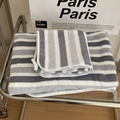 Close-up of grey and white striped towels with soft plush texture on a metal rack - Bath Towel / Grey Stripe