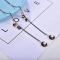 Golden eyewear chain featuring black and gold enamel moon pendant with star detail - Black Gold Moon