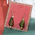 Christmas tree spiral drop earrings with gold stars on a festive red and green background - 15 Gold Star Green Spiral Tree