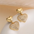 Elegant gold heart earrings with zircon studs and drop pendants on soft fabric - Gold