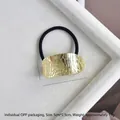 Detail of gold textured alloy U-shaped hair tie with dimensions 5cm x 2.5cm and 13g weight - Gold Leather Texture