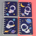 A7 pocket coil notebook with dark blue cartoon astronaut and space theme illustrations - Little Astronaut