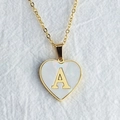 Gouden hartvormige schelpketing met hanger letter A op witte getextureerde stof - Letter A / Goud