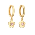 Macro detail of golden huggie hoop earrings featuring a floral pendant with pink zircon - Gold Pink Zirconia Flower