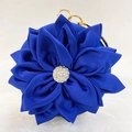 Macro detail of royal blue silk evening bag with floral design and golden ring handle - Blue