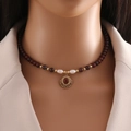 Detail of natural deep red beads and vintage gold pendant necklace on a female model - Red Agate Necklace