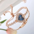 Macro detail of heart-shaped quartz watch with crystals on elegant mirror background - Blue