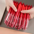 Mano che tiene un set sfuso di penne a sfera rosse a scatto con fusto trasparente - Pezzo Singolo / Rosso