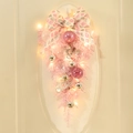 Rosa Weihnachts-Türhänger mit Schleifen und LED-Lichtern an einer weißen Tür - 60cm (Mit LED)