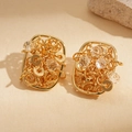Detalle de pendientes cuadrados bañados en oro de 18k con eslabones y cristales claros - Dorado