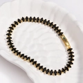 Detail of a golden tennis bracelet featuring black marquise-cut zircons in a shell bowl - Black Zircon - Gold