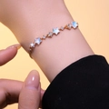 Κομψό χρυσό βραχιόλι αστέρι με λευκό οπάλιο και ζιργκόν σε γυναικείο καρπό - Χρυσό Βραχιόλι Αστέρι (S1108)