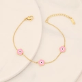 Detail of gold stainless steel bracelet with pink enamel flowers and evil eye motifs - Pink