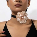 Detalle de una gargantilla de camelia de tela con diamantes de imitación en terciopelo - Color Piel