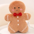 Gingerbread man plush toy in brown with red bow tie and white frosting details - Smiling Gingerbread Man