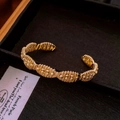 French vintage gold open bangle featuring textured oval links on a black jewelry box - Gold French Retro Carved (WB977)