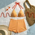 Set bikini a righe arancioni e bianche con pantaloncini e accessori coordinati in posa flat lay - S / Quadri Giallo
