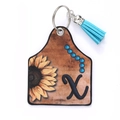 Western style faux leather sunflower ear tag keychain with vibrant blue tassel and X print - Letter X
