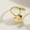 Macro shot of gold-plated heart ear cuff featuring a polished mirror finish and round metal ball - Heart / Gold