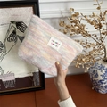 Dettaglio della borsa trucco in peluche arcobaleno con etichetta tessuta e trama soffice - Rosa