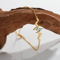 Macro shot of gold heartbeat necklace with blue topaz gemstone on rustic wood - Gold Natural Topaz Bracelet