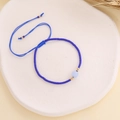 Close-up of Bohemian woven blue bead bracelet with gold accents and light blue center bead - Dark Blue
