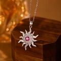 Makroaufnahme des Sonnenanhängers mit rotem Stein und Zirkonia auf Silberkette - Stahlfarbene Sonne Rote Strass Halskette