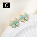 Detail of gold bow earrings featuring light blue marble texture enamel on white ceramic - Light Blue Marble