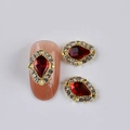 Gold teardrop nail charms with red gemstones and clear rhinestones on white background - Gold Base Waterdrop Red Gemstone