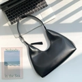 Minimalist black PU leather hobo bag with silver hardware for women in a lifestyle setting - Black